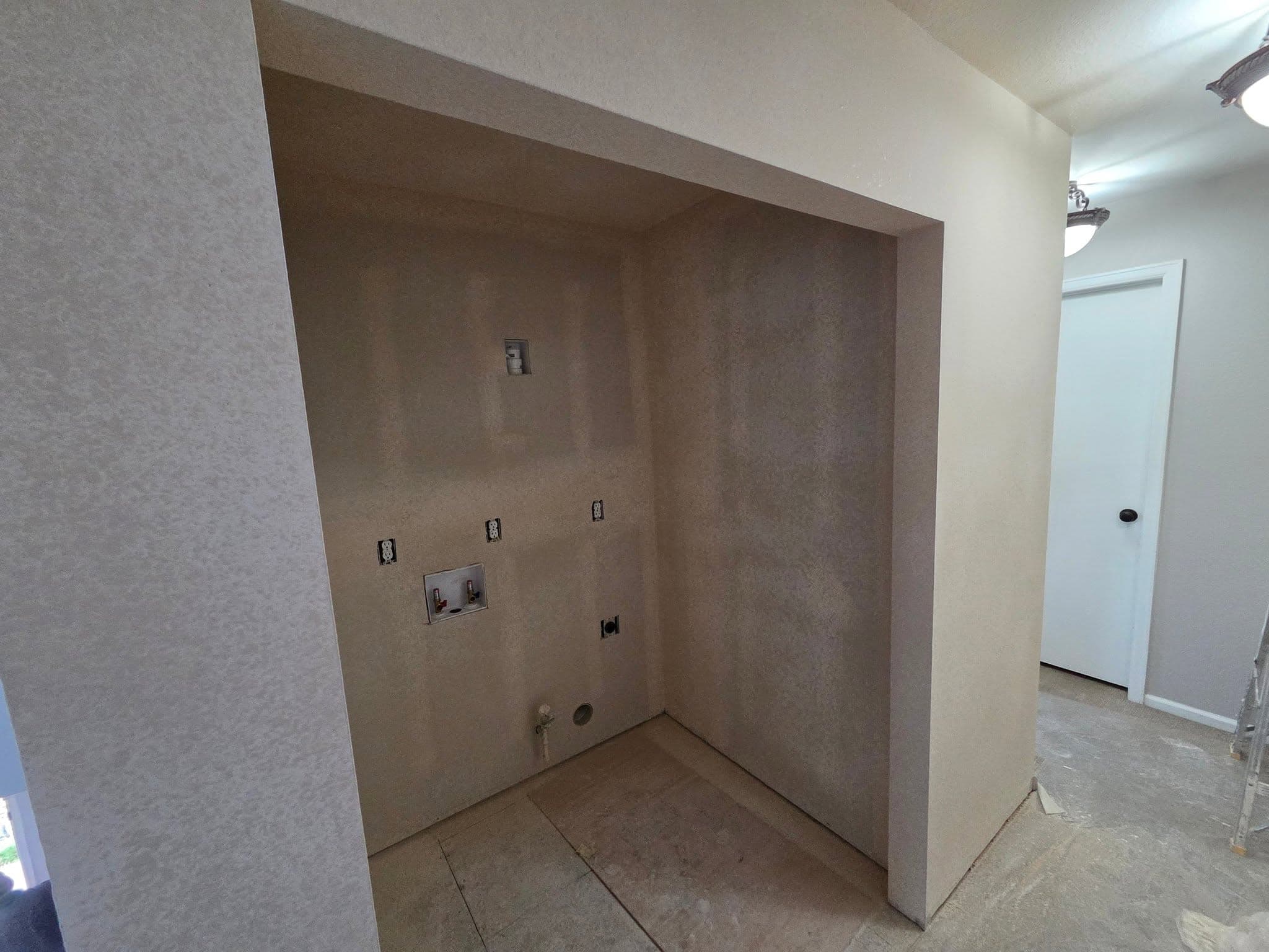 Drywall-finished interior nook with electrical outlet rough-in